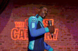 a man is holding a microphone in front of a brick wall that says the comedy club