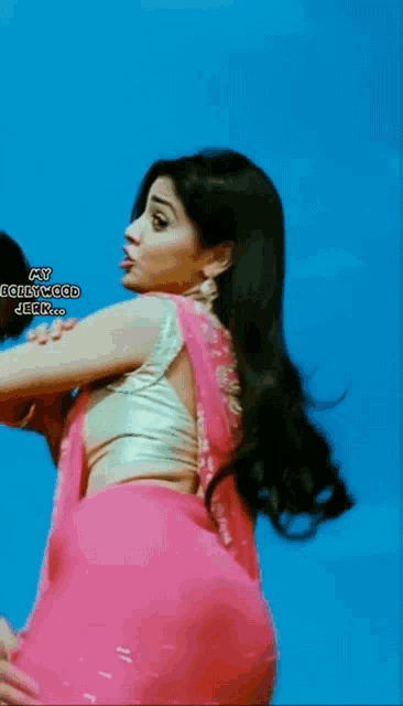 a woman in a pink saree is being held by a man in a gold top