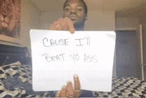 a man holding a sign that says cause i 'll beat yo ass