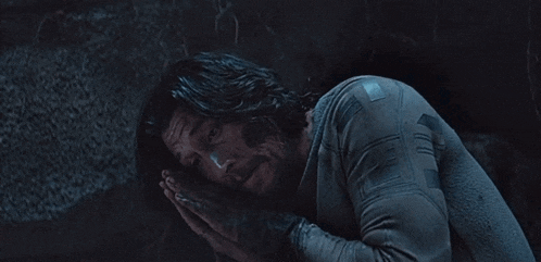 a man with long hair and a beard is wearing a grey shirt