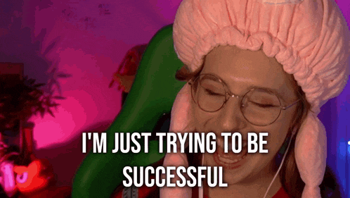 a woman wearing glasses and a pink hat is saying i 'm just trying to be successful