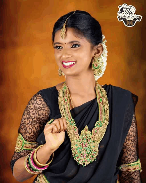 a woman wearing a black saree and gold jewelry with a fashion design logo