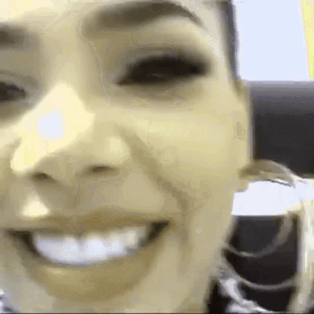 a close up of a woman 's face with a big smile .