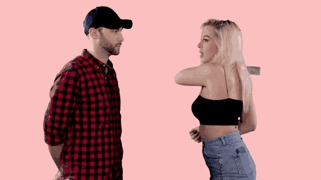 a man and a woman are standing next to each other on a pink background . the woman is throwing money at the man .