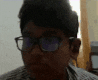 a blurry picture of a man wearing glasses and a striped shirt