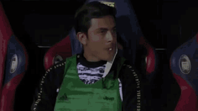 a man wearing a green vest that says jeep