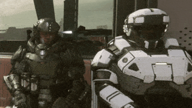 two futuristic soldiers are standing next to each other with one wearing a helmet that has the letter l on it