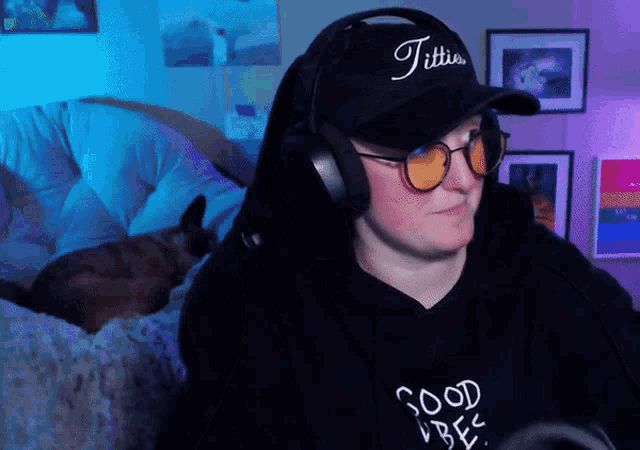 a man wearing headphones and a hat that says titties on it