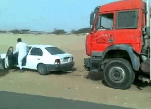 a car is being towed by a red truck .