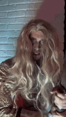 a man with long blonde hair is holding a knife