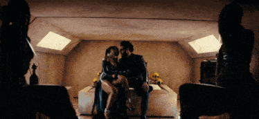 a man and a woman are sitting on a couch in a dark room
