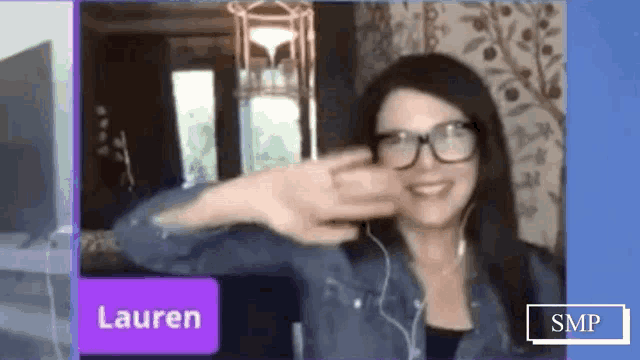 a woman wearing glasses and ear buds is being interviewed by lauren