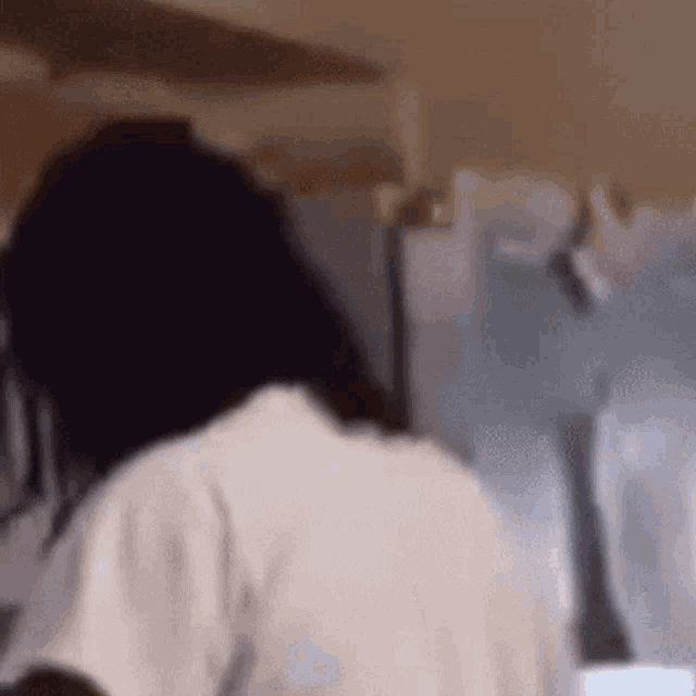a blurry picture of a person 's back with a white shirt