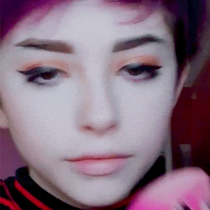 a close up of a person 's face with a striped shirt