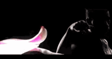 a man is standing in front of a red and pink flower .