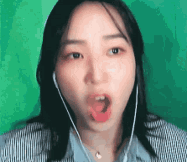 a woman wearing headphones making a funny face with her mouth open