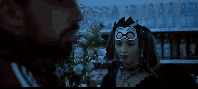a woman wearing a mask with the number 66 on it stands next to a man