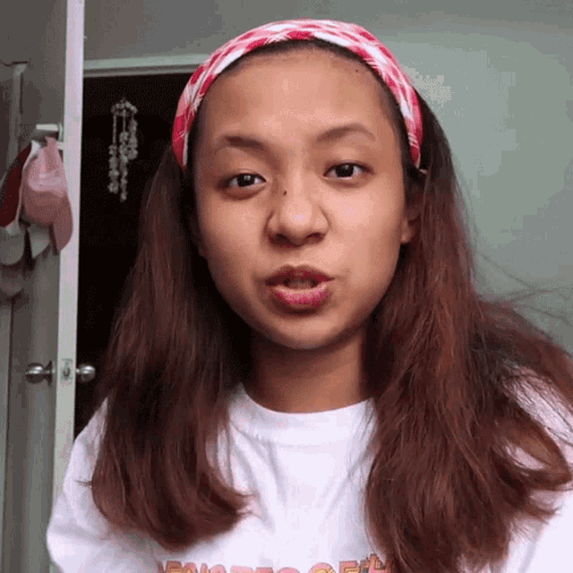 a woman wearing a headband and a t-shirt that says ' i 'm sorry ' on it