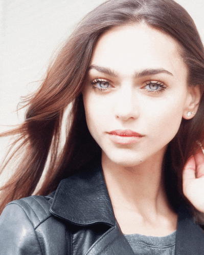 a woman wearing a black leather jacket looks at the camera