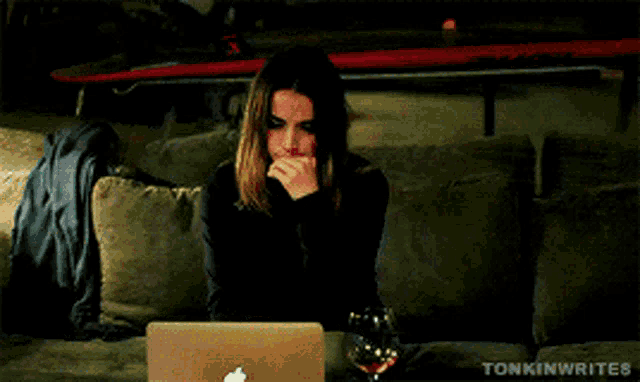 a woman is sitting on a couch in front of a laptop that says ' sonkirrice ' on the screen