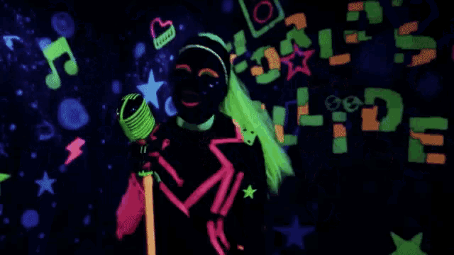 a woman in a glow in the dark outfit singing into a microphone