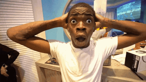 a man with a surprised look on his face is wearing a white shirt