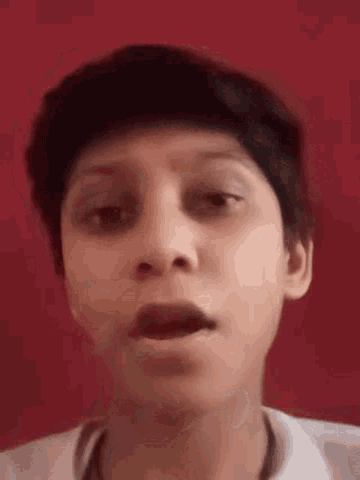 a young boy with short hair is making a funny face .