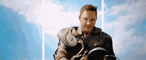 a man is standing in front of a blue sky holding a frying pan in his hands .