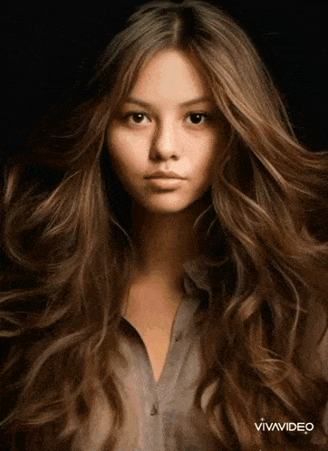 a woman with long brown hair looks at the camera with vivavideo written on the bottom
