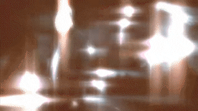 a blurred image of a person 's face with a few lights behind it