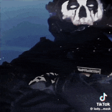 a person wearing a mask with a skull on it is holding a gun .