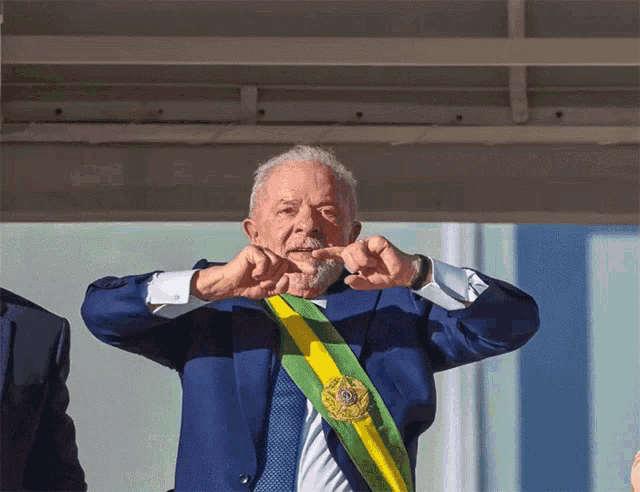 a man in a blue suit has a green and yellow sash around his neck that says ' brasil ' on it