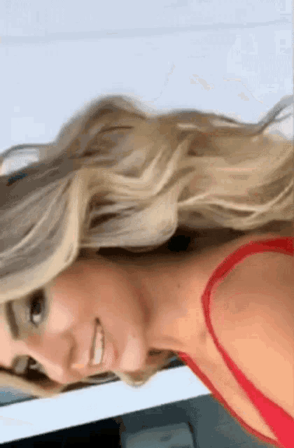 a woman in a red bra is smiling and looking at the camera .