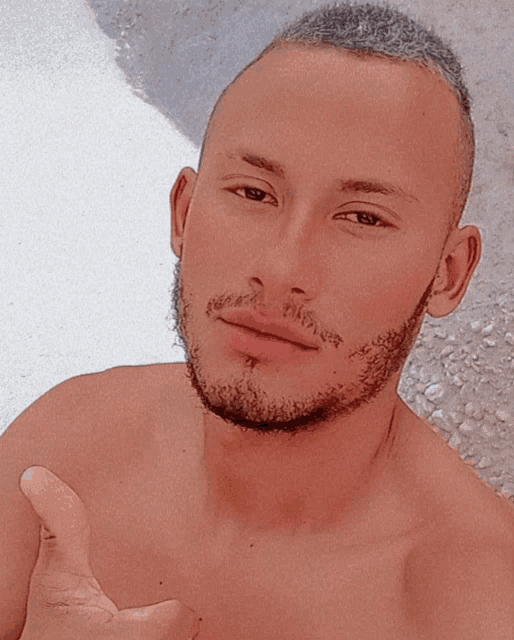 a shirtless man giving a thumbs up with a tattoo on his face