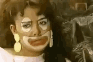 a close up of a woman 's face with a clown face painted on it .