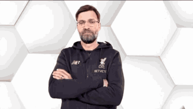 a man with glasses and a beard wearing a new balance sweatshirt