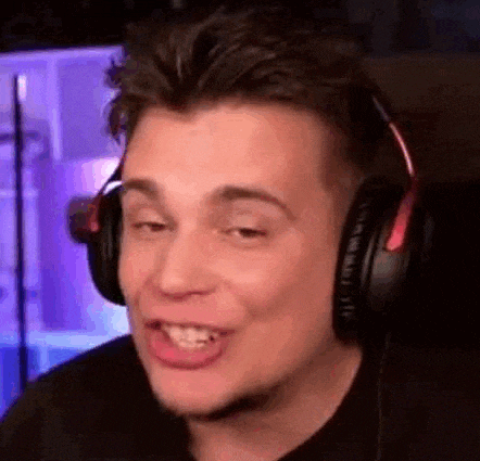 a man wearing headphones is making a funny face while sitting in front of a computer .