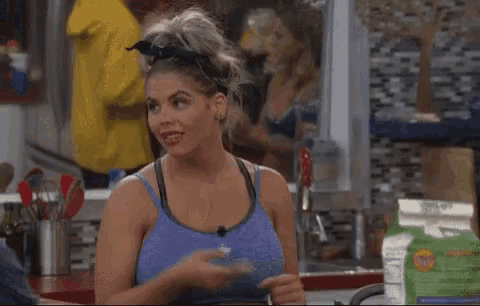 a woman in a blue sports bra is sitting at a table with a carton of milk in front of her ..