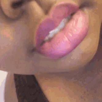 a close up of a woman 's mouth with pink lipstick on it .