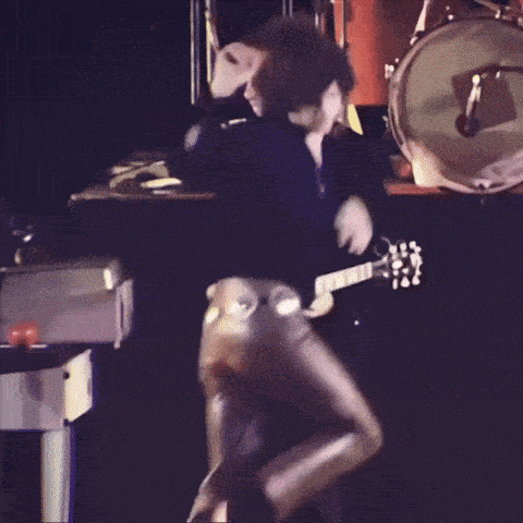 a man is playing a guitar in front of a drum