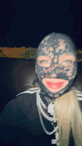 a person wearing a mask and a necklace with their mouth open