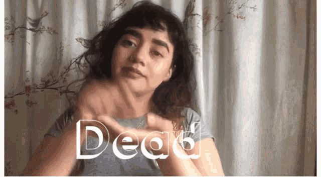 a woman is making a gesture with her hands and the word dead is visible