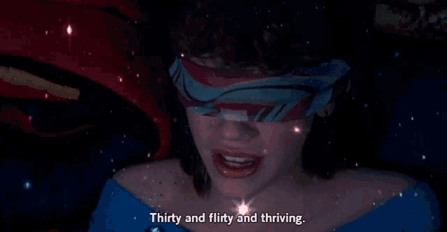 a woman with a scarf around her eyes says " thirty and flirty and thriving "