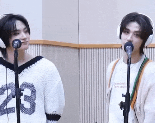 a man wearing a number 23 sweater stands next to another man