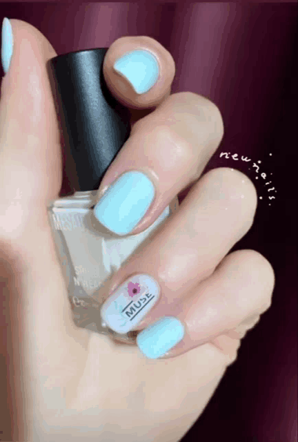 a woman holds a bottle of muse nail polish on her finger