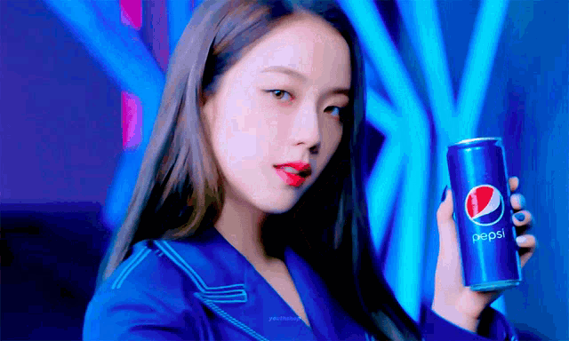 a woman in a blue suit is holding a can of pepsi .