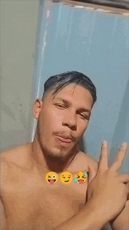 a shirtless man is sticking his tongue out in front of a blue wall