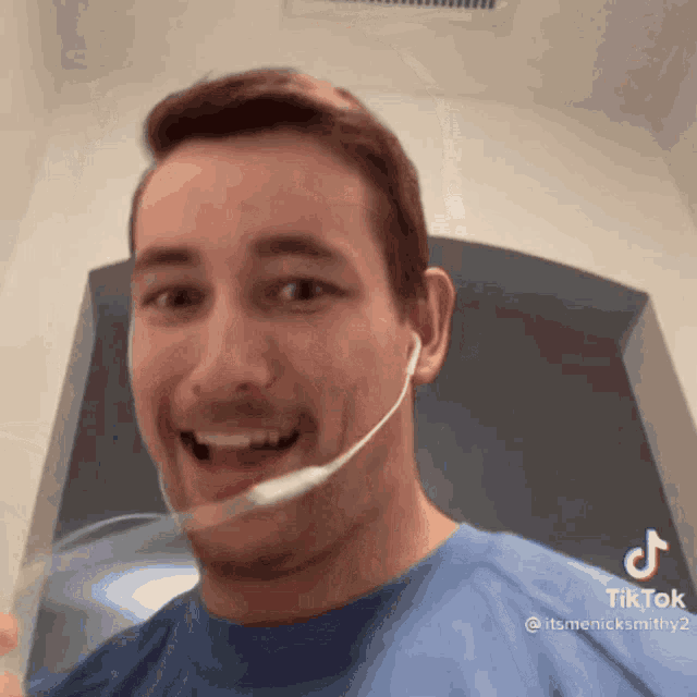 a man in a blue shirt has a spoon in his mouth and a tiktok written on the bottom