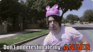 a man wearing a pink helmet and a pink shirt says " don 't underestimate my anger "