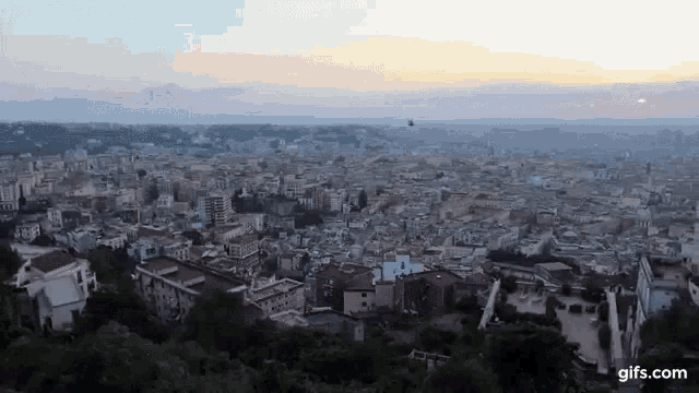 an aerial view of a city at sunset with the website gifs.com at the bottom